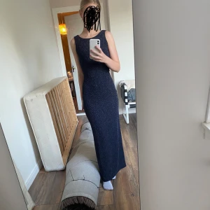 Aftonklänning från drylake - Superfin glittrig svart/mörkblå långklänning från drylake i storlek xs. Det är i superfint skick! Det har en v-ringad öppen rygg, boatneck och en slits där bak. Hör av dig vid frågor🥰☺️