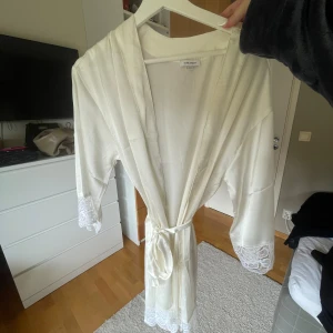 Silkes morgonrock - Denna morgonrocken har bara hängt i min garderob sedan jag köpte den, superfin och smidig att ha hemma! Den är i nyskick med spets vid armarna och nedtill.