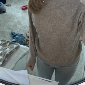 Beige stickad tröja - Mysig beige stickad tröja perfekt för kyliga dagar. Den har en normal passform och långa ärmar, vilket gör den superbekväm att ha på sig. Tröjan är enkel men stilren, vilket gör den lätt att matcha med olika outfits.