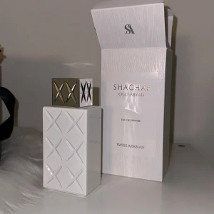 Shaghaf Oud Abyad Eau de Parfum från Swiss Arabian - Säljer en lyxig parfym, Shaghaf Oud Abyad Eau de Parfum från Swiss Arabian. Flaskan är vit med ett elegant rutmönster och har en guldig kork med ett snyggt X-mönster.  Parfymen är endast sprayad några gånger.   