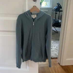 Zip up hoodie från soft goat  - Tröjan är i en grönblå färg och är i fint skick, och är i 100 procent cashmere. Tröjan är köpt i softgoats egna butik. Köparen står också för frakt.