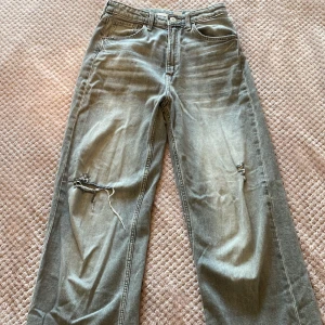 Gråa jeans - Gråa baggy jeans. High waist. Justerbar midja. Är lite sliten på ett av hålen som syns på bild 3 annars är de i bra skick. Säljer eftersom de inte passar längre och inte min stil. Pris kan alltid diskuteras. ❤️