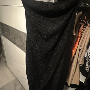 Svart glittrig klänning - Säljer en elegant svart klänning från Gina Tricot med glittrande detaljer. Perfekt för festliga tillfällen! Klänningen har en smickrande passform och är i nyskick. Passar perfekt för speciella tillfällen.