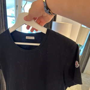 Moncler T-shirt  - Säljer denna T-shirt från moncler då den nu är förliten! Jätte bra kvalite använd fåtal gången! Tröjan är junior tröja och storlek XL. Passar bäst dig som är 165-180. Hör av er vid minsta fundering!