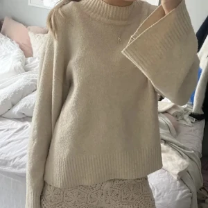 Beige stickad tröja med vida ärmar - Superfin beige stickad tröja med vida ärmar som ger en riktigt mysig känsla. Perfekt för kyliga dagar när du vill vara både bekväm och stilren😍🍁