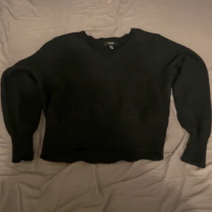 Svart tröja från Vero Moda - Säljer en stilren svart stickad tröja från Vero Moda. Tröjan har en v-ringad design och långa ärmar, perfekt för en enkel och elegant look.💕använd fåtal gånger.