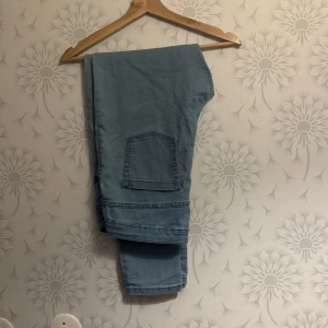 Ljusblå jeansbyxor - Snygga ljusblå jeansbyxor med en klassisk design. Byxorna har en rak passform och en praktisk bakficka. Perfekta för en avslappnad stil.