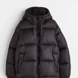 Svart pufferjacka - Snygg och varm svart pufferjacka med huva och dragkedja. Storleken är xxs men den är oversize så passar en xs kanske s😍😍 super trendig och slutsåld 