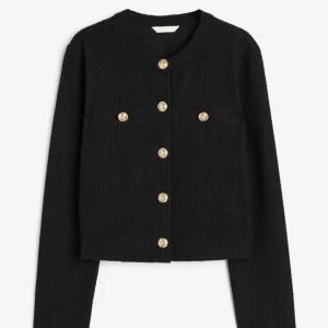 Svart kavaj med guldknappar - Elegant svart kavaj med rund hals och guldknappar framtill. Den har en croppad passform och långa ärmar. Perfekt för en stilren look. Från H&M, storlek S