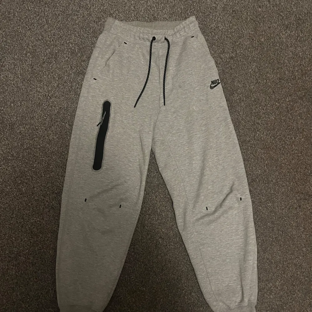 Säljer mitt gråa nike tech set som aldrig kommer till användning:) Köpte setet för något/några år sedan på stadium i USA men jag har bara använt de ett fåtal gånger. Perfekt för en sportig look eller avslappnade dagar. Jag kan tvätta de innan det säljs så att de lilla smink fläckarna som finns vid kragen försvinner!:) Annars är de i princip i nyskick! Nypris: ca 2000kr. Neuletakit & Villapaidat.