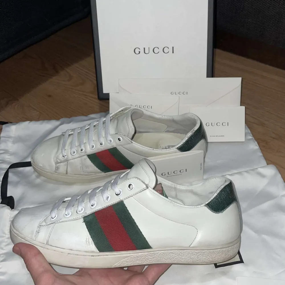 Snygga vita sneakers från Gucci med klassiska gröna och röda ränder på sidan. Skorna har snörning och en stilren design som passar perfekt för en trendig look. OBS ingår bara dustbag och kort ❗️ ❗️ . Kengät.
