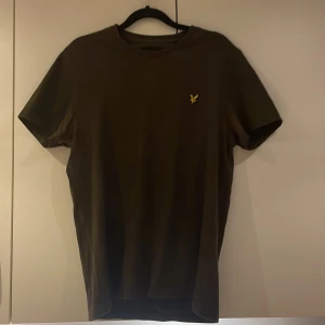 T-shirt i rött och brunt från Lyle & Scott - Två stilrena t-shirts från Lyle & Scott i rött och brunt. Båda har en liten broderad logotyp på bröstet. Perfekta för en avslappnad look. Köp två betala för en. 