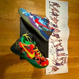 Nike Kobe 8 VIII what the basketskor - Säljer ett par färgglada sneakers med unikt mönster och kontrasterande färger. Skorna har snörning och en mix av gröna, röda, blå och lila nyanser. Perfekta för den som vill sticka ut med sin stil.
