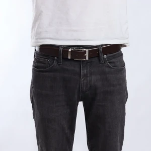 Brunt skärp med silverfärgat spänne - Snyggt brunt skärp med ett stilrent silverfärgat spänne. Perfekt för att ge en klassisk touch till din outfit. Passar bra till både jeans och kostymbyxor.