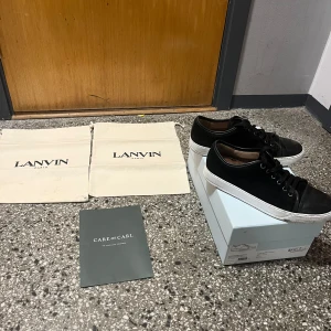 Svarta sneakers från Lanvin - Snygga svarta sneakers från Lanvin med vit sula och klassisk snörning. Perfekta för en stilren look. Skorna kommer med originalförpackning och dustbags. Kvitto o allt finns på bild, Hör av om dig om du har en fråga. 