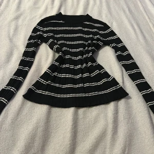Svart och vit randig tröja från H&M - Säljer en svart och vit randig tröja från H&M. Tröjan är ribbad med långa ärmar och har en klassisk passform. Perfekt för en stilren look.
