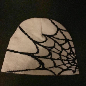 Snygg vit mössa - Snygg vit mössa med ett coolt svart spindelnätsmönster. Perfekt för att ge din outfit en unik touch. Passar bra till både höst och vinter. Pris kan diskuteras 