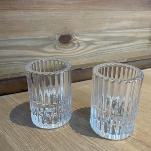 Räfflade ljuslyktor i glas - Två stilrena ljuslyktor i klart glas med räfflad design. Perfekta för att skapa en mysig atmosfär i hemmet. Passar utmärkt för värmeljus och ger ett vackert ljusspel.