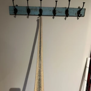 Flätat bälte med svart läderdetalj - Snyggt flätat bälte i beige och grått med en stilren svart läderdetalj vid spännet. Perfekt för att ge en extra touch till din outfit. Spännet är i metall och ger en robust känsla.