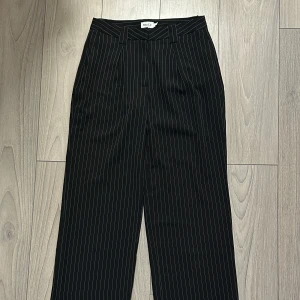 Svarta randiga byxor från NA-KD - Snygga svarta byxor från NA-KD med vita ränder. Byxorna har en medelhög/hög midja och raka ben!💙