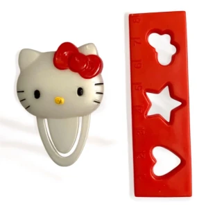 McDonald’s  X Hello Kitty gem och röd linjal  - Söt Hello Kitty gem i vitt med en röd rosett. Inkluderar en röd stencil/linjal med former som blomma, stjärna och hjärta. Perfekt för pyssel. Vintage från 2007.