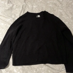 Svart stickad tröja från Divided - Säljer en stilren svart stickad tröja från Divided. Tröjan har en klassisk design med ribbade muddar vid ärmslut och nederkant. Perfekt för kyligare dagar och enkel att matcha med olika outfits. 🖤