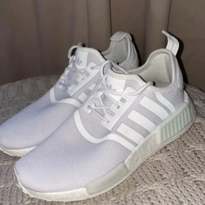 Vita sneakers från Adidas - Snygga vita Adidas sneakers med klassiska tre ränder på sidan. Skorna har en modern design med snörning och en bekväm sula. Perfekta för en stilren look.