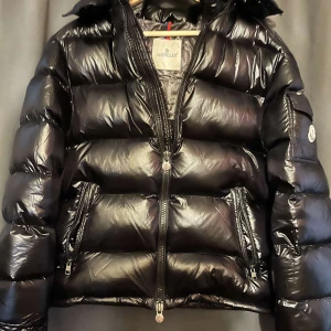 Svart Moncler Maya i nyskick  - Säljer den perfekta vinter jackan för en bra peng. Det är en svart Moncler Maya i ny skick. Det är storlek 2 vilket är S/M i storlek. Hör av dig vid funderingar. NFC Scan funkar!