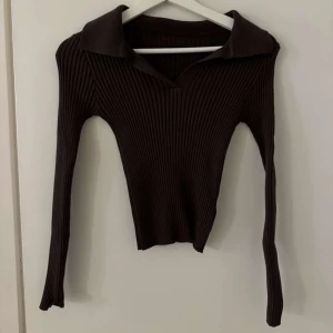 Brun ribbad tröja med krage - Snygg brun ribbad tröja med krage och långa ärmar.