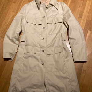Vintage kappa - Beige kappa med sleif bak Blankt foder. Finns ingen strl men uppskattar till S