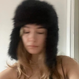 Svart pälsmössa - Säljer en supermysig svart pälsmössa som är perfekt för kalla vinterdagar. Mössan har öronlappar som håller dig varm och ser riktigt stilren ut. Den är i mycket bra skick och passar perfekt för vinterns alla äventyr. 🖤