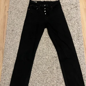 Levi’s 501 - Säljer ett par svarta Levi’s 501 jeansbyxor i mycket bra skick. De har en klassisk design med knappar fram och fem fickor. Perfekta för både vardag och fest. Passar bra till alla säsonger och är ett måste i garderoben!
