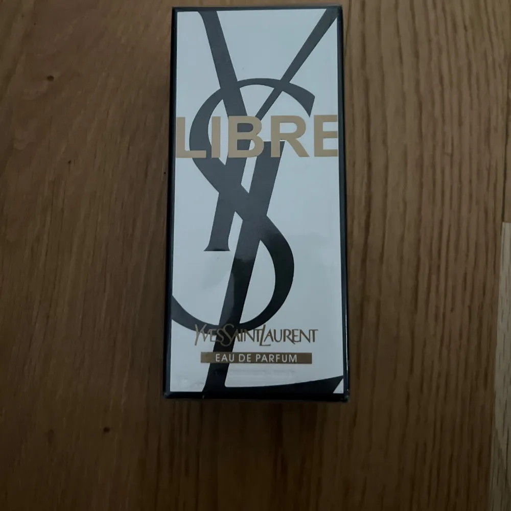 Säljer en elegant och lyxig parfym från Yves Saint Laurent, Libre Eau de Parfum. Flaskan är 90 ml och kommer i en stilren svart och vit förpackning med guldtext. Perfekt för den som vill ha en sofistikerad doft som håller hela dagen. Helt ny och oöppnad!. Parfym.