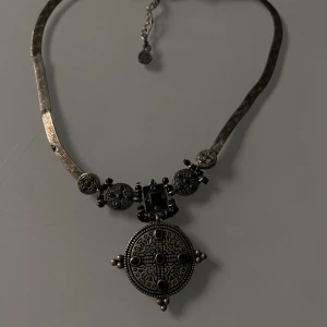 Antikt halsband med detaljerad medaljong - Unikt halsband med en stor, detaljerad medaljong i antik stil. Kedjan har ett vackert mönster och justerbar längd. Perfekt för att ge en vintage touch till din outfit.