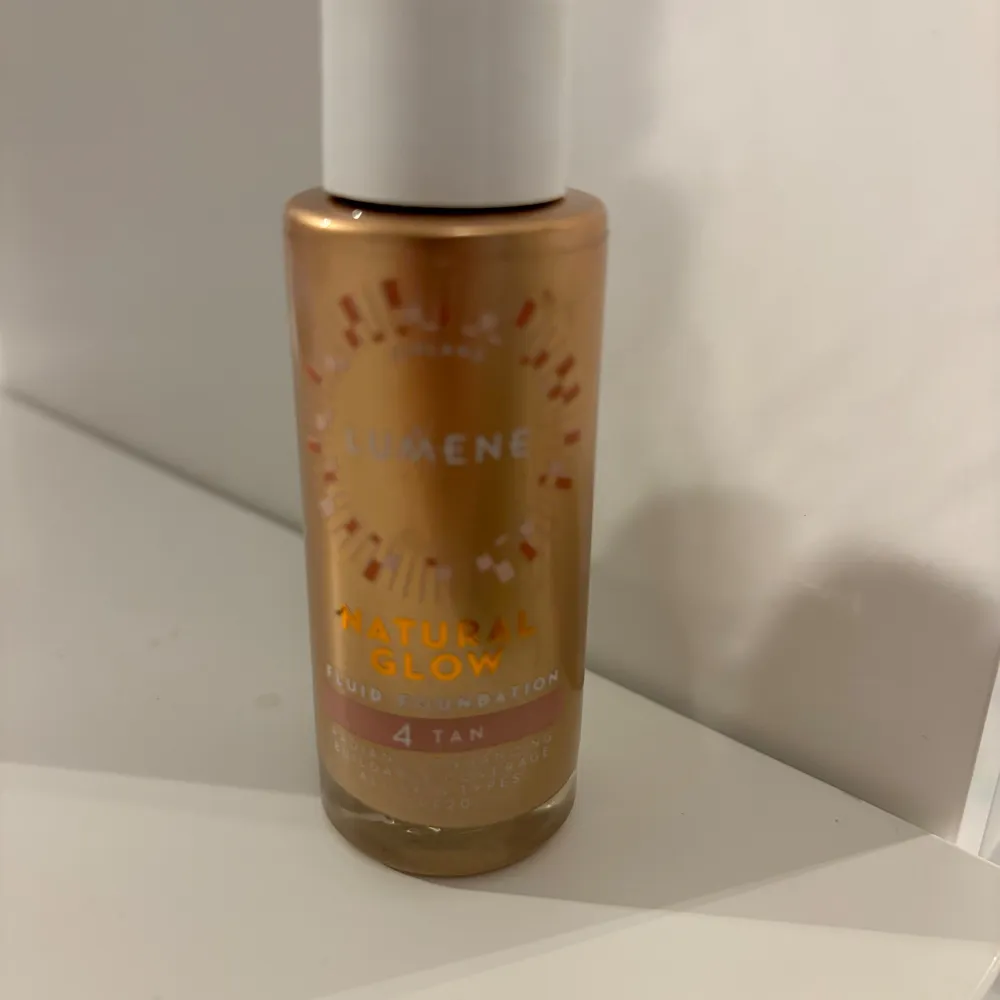 Säljer en flaska Lumene Natural Glow Foundation i nyansen 4 Tan. Den ger en naturlig lyster och jämn hudton. Perfekt för en solkysst look! Flaskan har en praktisk pump för enkel applicering.. Skönhet.