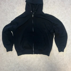 Svart hoodie med dragkedja ziphoodie - Oversize svart hoodie med dragkedja framtill. Den har en mysig huva och praktiska fickor. Perfekt för kyliga dagar eller som ett extra lager. Inga defekter. Har dragit ut snörena