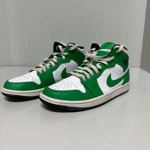 Nike Air Jordans i grönt och vitt - Säljer ett par grönvita Air Jordan 1 se mid. Lite tecken på andvändning bara en lite sliten innersula. Pris är ej hugget i sten och tveka inte vid frågor eller mera bilder!