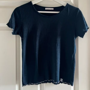 Mörkblå ribbad topp  - Säljer en mörkblå ribbad topp i bra skick i storlek S