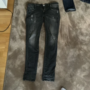 Svarta jeans från Replay - Säljer ett par svarta Replay Anbass jeans i slim fit. De har en snygg tvättad look med diskreta slitningar och klassiska fem fickor. Perfekta för både vardag och fest! 🖤