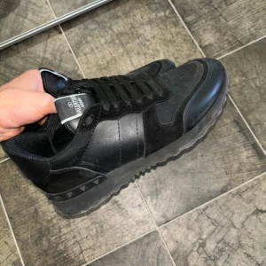 Valentino rockrunners - Säljer ett par snygga svarta Valentino sneakers i bra skick. De har en stilren design med snörning och en robust sula. Perfekta för både vardag och fest! Skorna är bekväma och passar till de flesta outfits. Hör av dig vid intresse! Storlek 41, finns att hämta i stockholm 😀