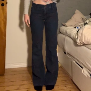 Blå bootcut jeans - Jättefina blå bootcut jeans från 808 wedsers. Har röda sömmar som detaljer 