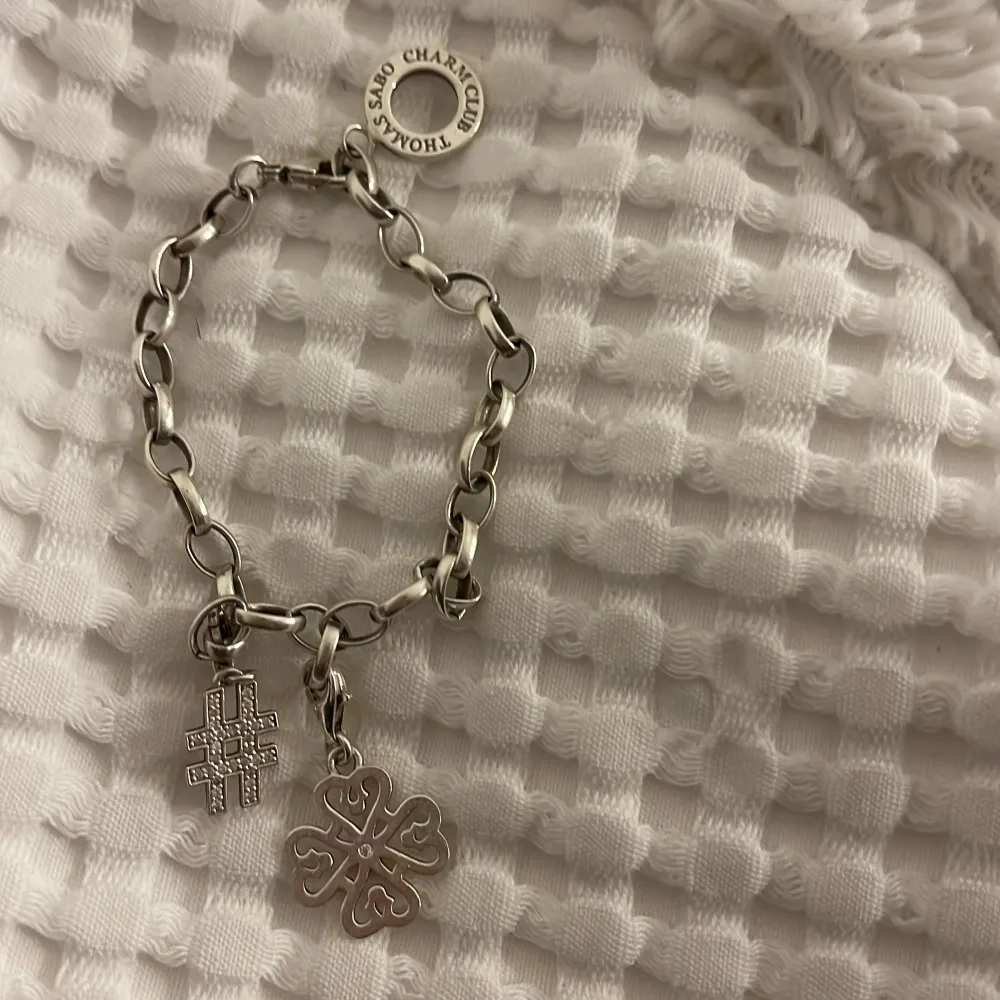 Snyggt silverarmband från Sabo Charm Club med två unika berlocker. Ena berlocken har ett intrikat korsmönster och den andra är formad som en fyrklöver.  Superfin hade lätt använd om det inte vore att jag använder guldsmycken:/ . Accessoarer.