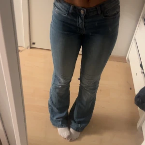 Blå bootcut jeans - Säljer ett par snygga blå bootcut jeans från pieces storlek 34 men stretchiga low/midwaist, lite slitna nedtill 