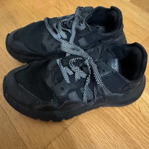 Svarta sneakers med snörning - Säljer ett par svarta Adidas sneakers i bra skick. Perfekta för vardagsbruk eller träning. Sköna och stilrena, säljer då de ej kommer till användning❤️ Pris kan diskuteras.
