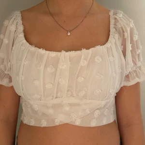 Blus - Söt blus med knytning i ryggen och vita små blommor på. Storlek S