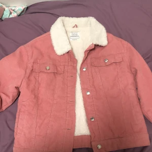 Rosa manchesterjacka med teddyfoder - Säljer en superfin rosa manchesterjacka från primark . Den har ett mysigt vitt teddyfoder och knappar framtill. Perfekt för höst och vår när det är lite kyligt ute. Jackan har långa ärmar och två bröstfickor med knappar. Passar perfekt till en casual look!