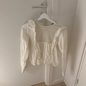 Zara blus - Vit blus från Zara med spetta och volang. Super fin men har ett litet hår i spetsen som lampor syns 