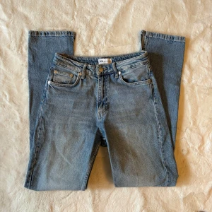 Zara jeans - Säljer ett par klassiska blå jeans från Zara i storlek 38. De är högmidjade med en straight passform och har en snygg vintage-look. Perfekta för både vardag och fest! 🦋 