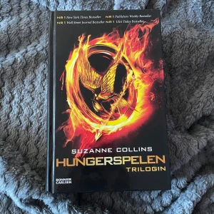 Hungerspelen Trilogin - Säljer Hungerspelen Trilogin av Suzanne Collins. Innehåller alla tre böcker: Hungerspelen, Fatta Eld och Revolt. Boken är i bra skick dock lite gammal.