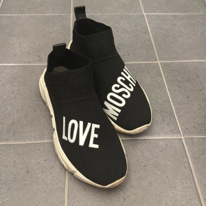 Svarta sneakers från Love Moschino - Säljer ett par svarta sneakers från Love Moschino. Skorna har en chunky vit sula och ett hjärta på undersidan. 